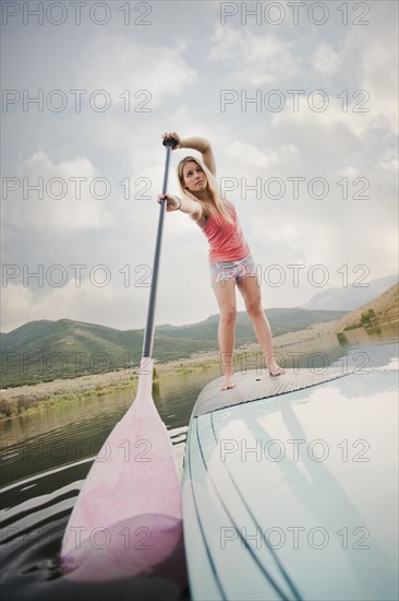 Caucasian woman on stand up paddle board