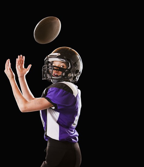 Mixed race football player catching football