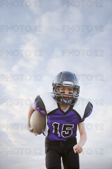 Mixed race football player running with football