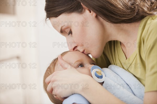 Caucasian mother kissing baby boy