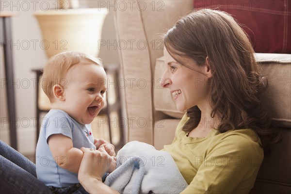 Caucasian mother sitting with son in her lap