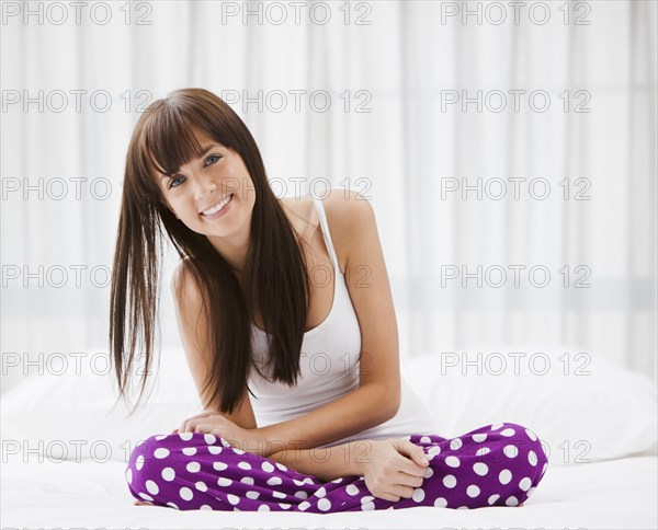 Caucasian woman sitting on bed