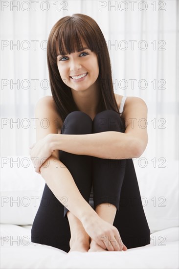 Caucasian woman sitting on bed