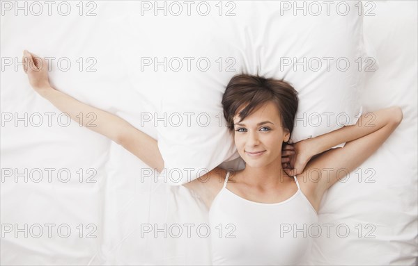 Caucasian woman stretching in bed