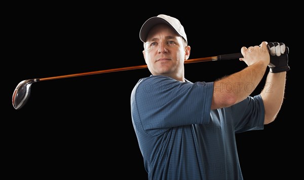 Caucasian golfer swinging golf club