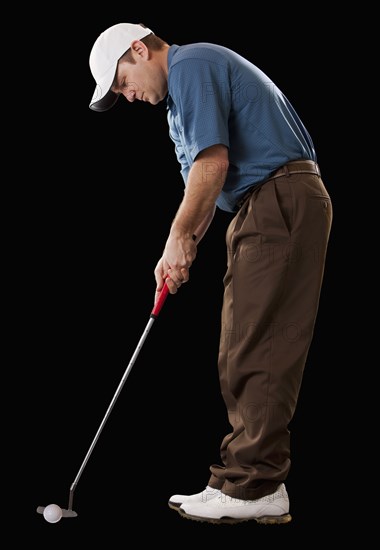 Caucasian golfer putting golf ball