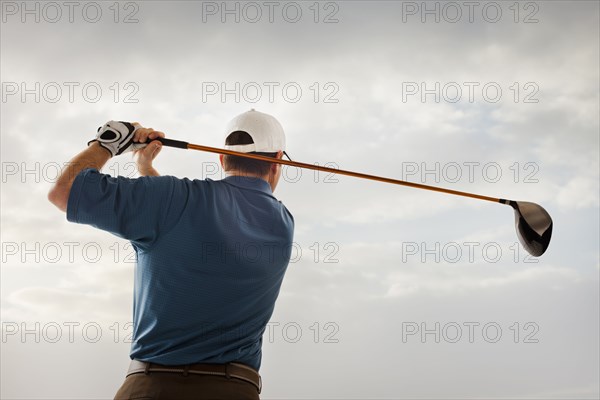 Caucasian golfer swinging golf club