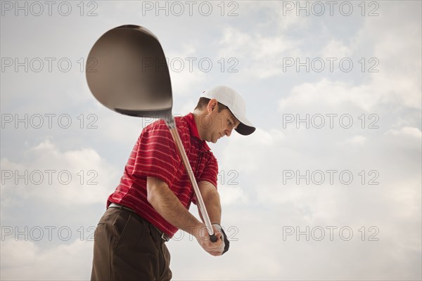 Caucasian golfer swinging golf club