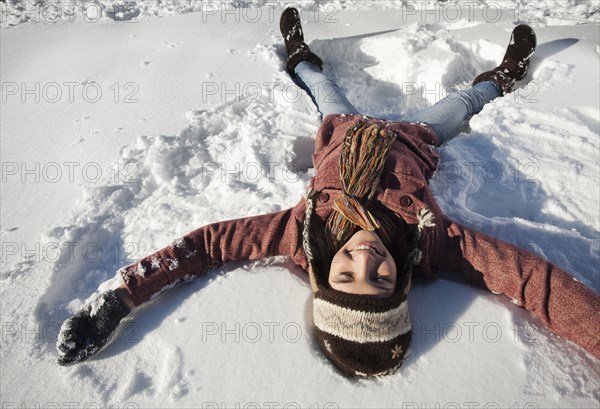 Caucasian woman making snow angel