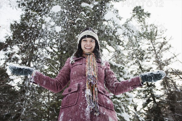 Caucasian woman throwing snow