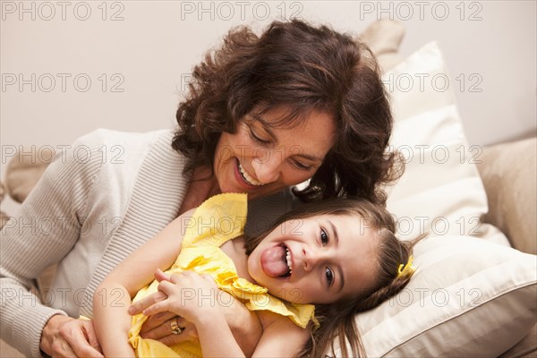 Caucasian grandmother tickling granddaughter