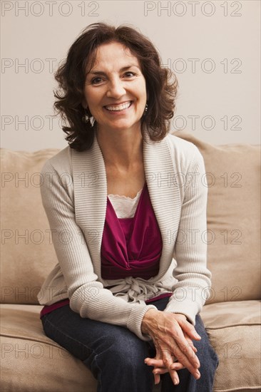 Smiling Caucasian woman sitting on sofa