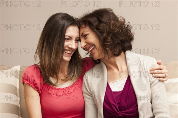 Caucasian mother and daughter sitting on sofa