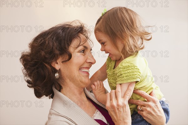 Caucasian grandmother holding granddaughter