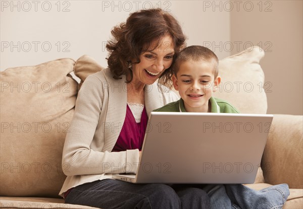 Caucasian grandmother and granddaughter using laptop