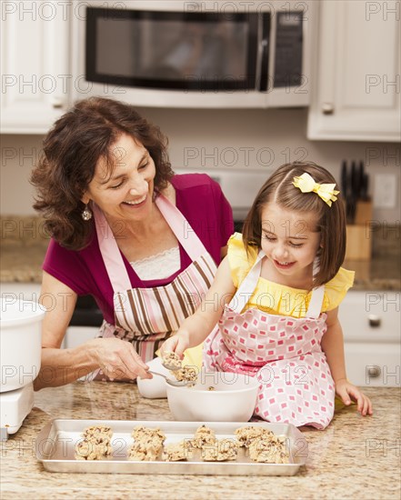 Caucasian grandmother and granddaughter baking cookies