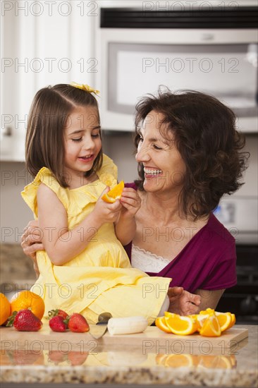 Caucasian grandmother and granddaughter eating fruit