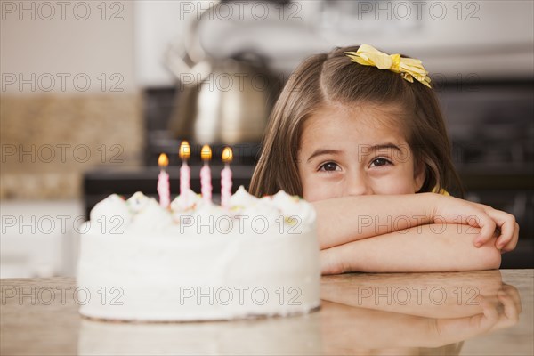 Caucasian girl looking at birthday cake