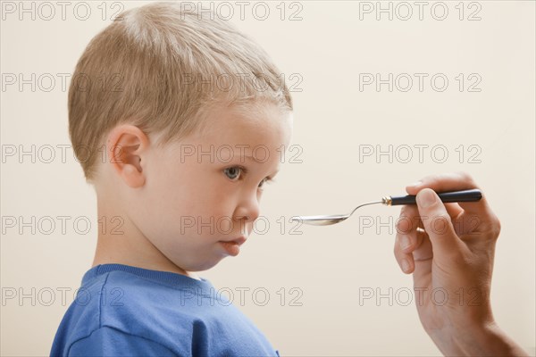 Caucasian boy taking medicine