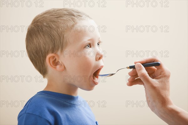 Caucasian boy taking medicine