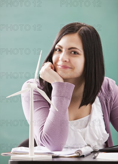 Caucasian woman sitting with wind turbine model