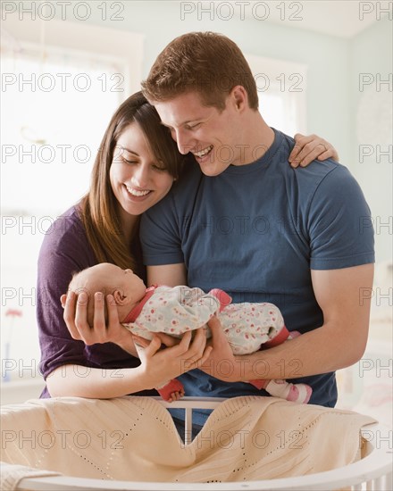 Caucasian parents holding baby girl