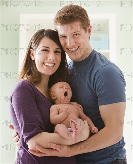 Caucasian mother and father holding baby girl