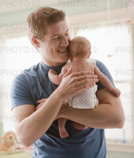 Caucasian father holding baby girl