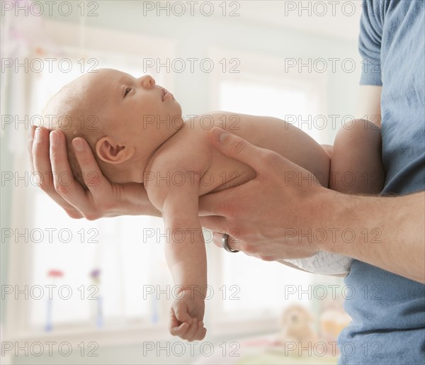 Caucasian father holding baby girl