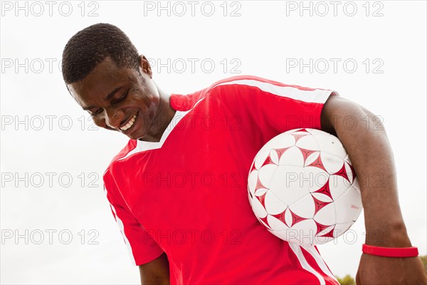 Black soccer player holding ball