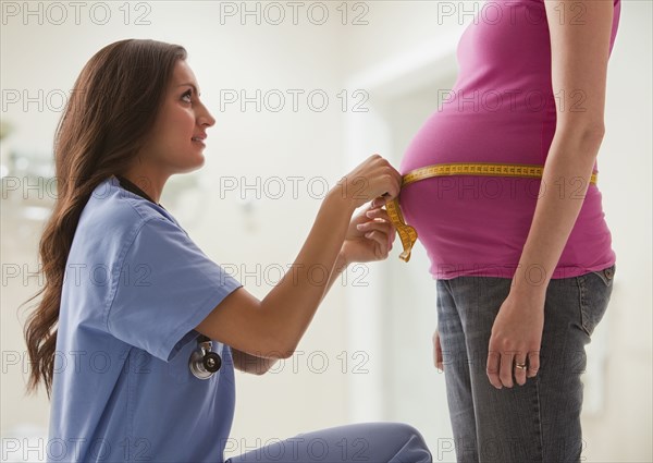 Nurse measuring pregnant woman's stomach