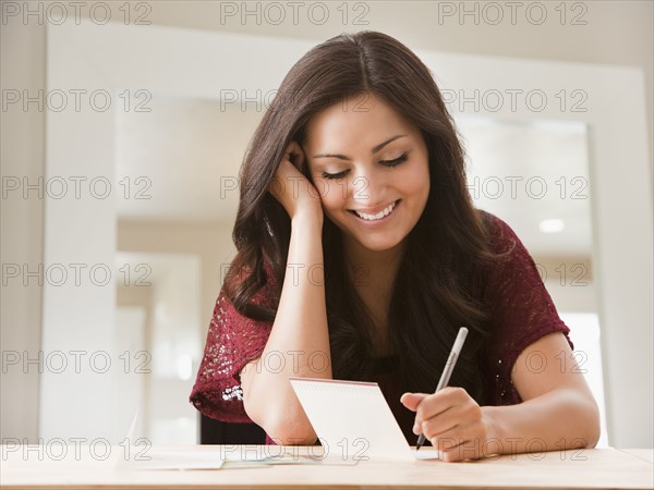 Mixed race woman writing card