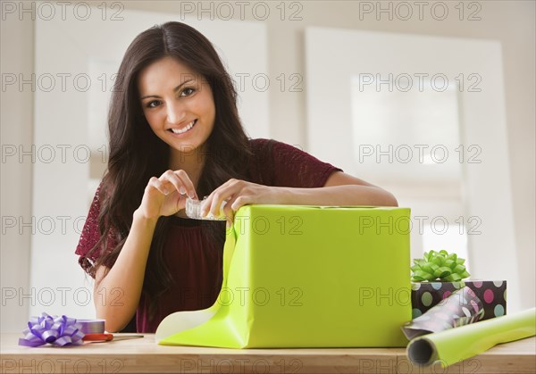 Mixed race woman wrapping gift