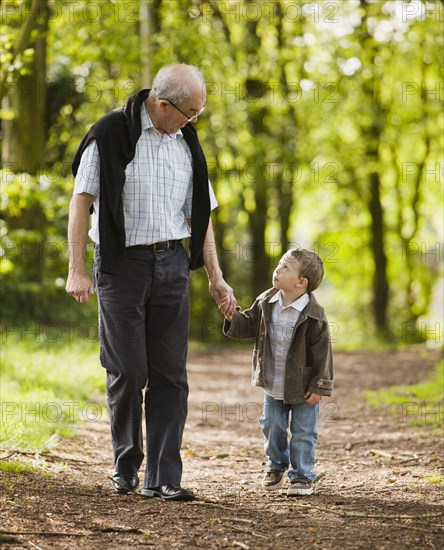 Caucasian grandfather and grandson walking in woods