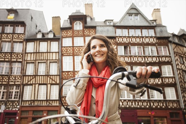 Caucasian woman riding bicycle and talking on cell phone