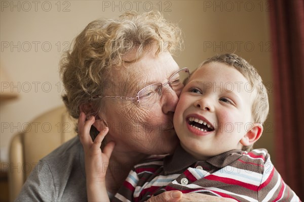 Caucasian grandmother kissing grandson