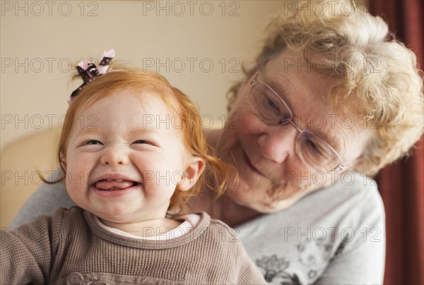 Caucasian grandmother sitting with granddaughter