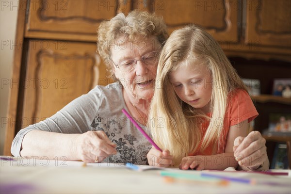Caucasian grandmother helping granddaughter with homework