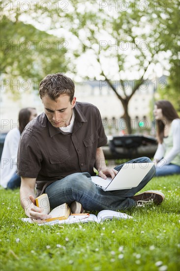 Caucasian man studying in grass