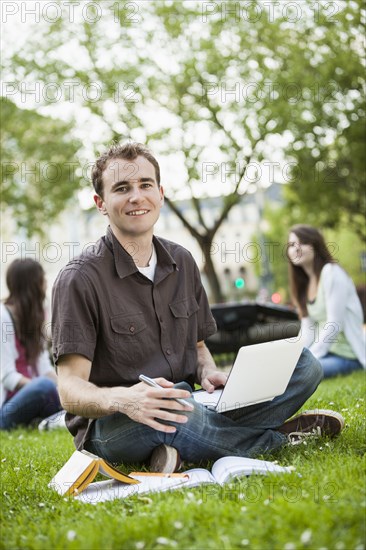 Caucasian man studying in grass