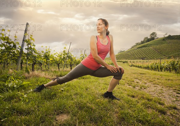 Caucasian woman stretching in vineyard