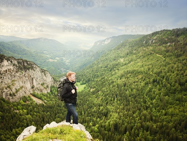 Caucasian man standing on remote cliff