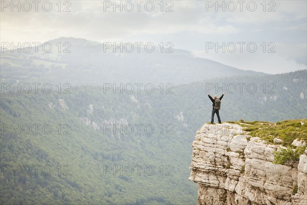 Caucasian man standing on remote cliff