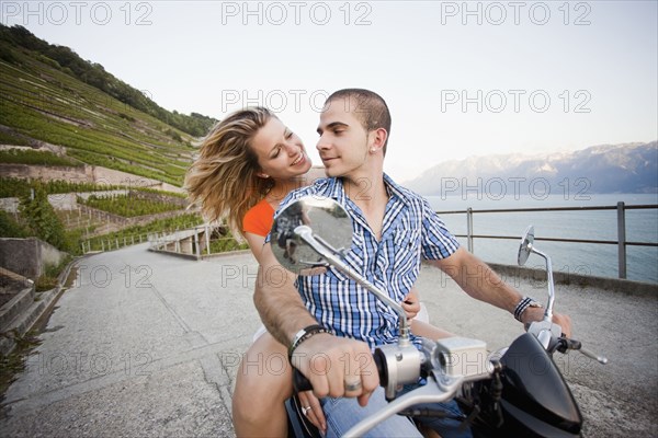 Couple riding scooter together