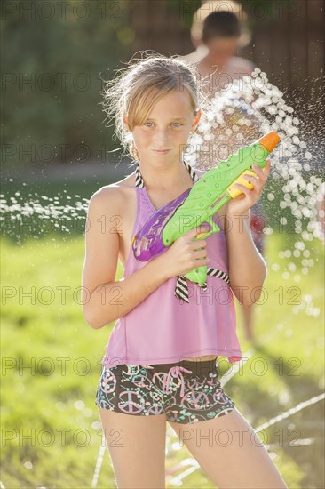 Caucasian girl holding a water gun