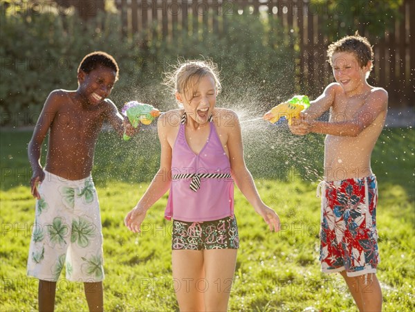 Boys squirting girl with water guns
