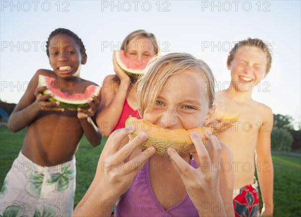 Children eating cantaloupe and watermelon