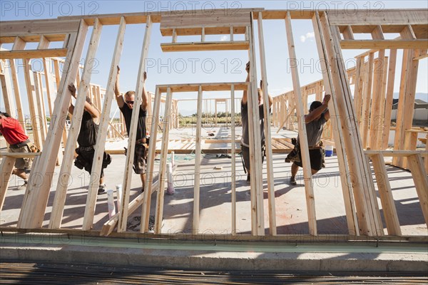 Workers lifting frame on construction site