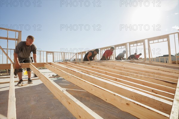 Workers lifting frame on construction site