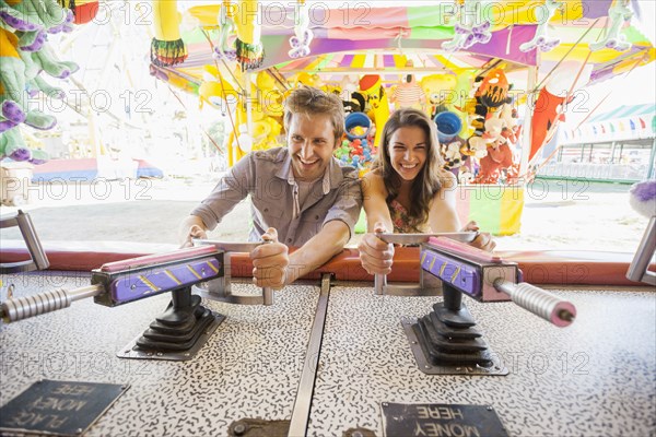 Caucasian couple playing games at carnival